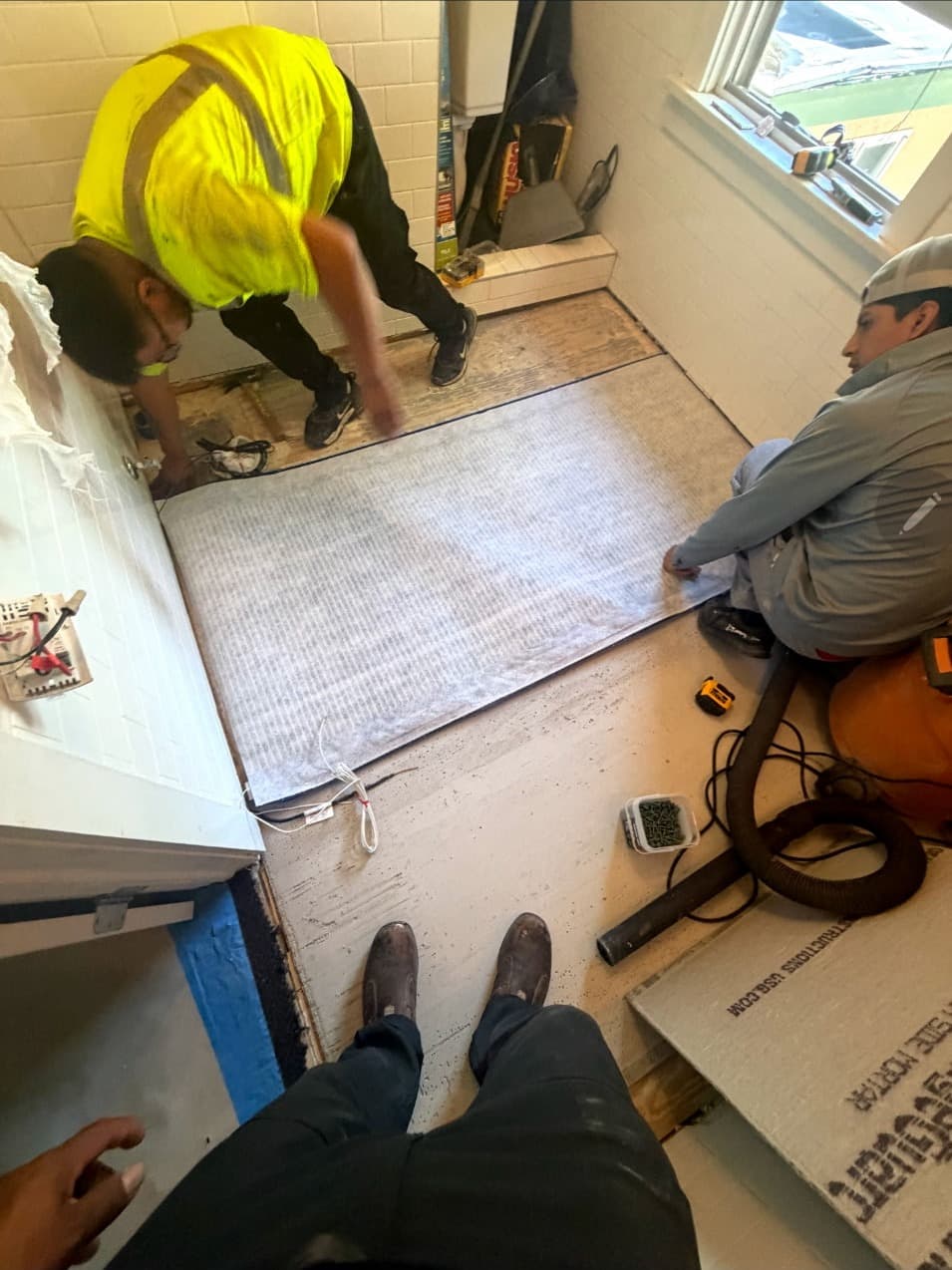 Bathroom tile floor being installed during a Minneapolis remodel