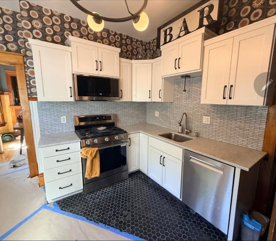 Remodeled Minneapolis kitchen with white shaker cabinets, tile backsplash and black hex tile floor
