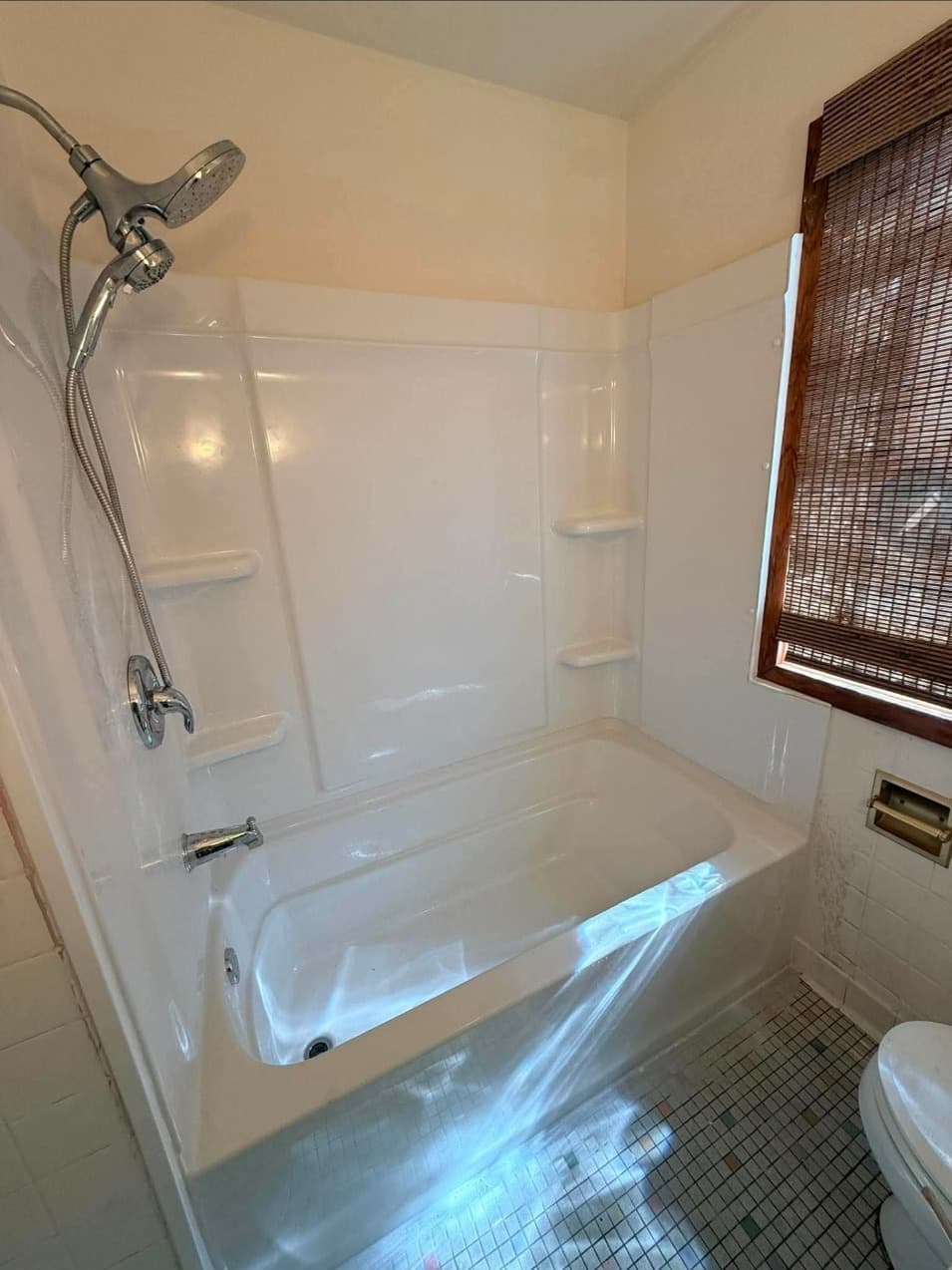 Finished tub and shower surround with new shower head and corner shelves in Minneapolis, MN