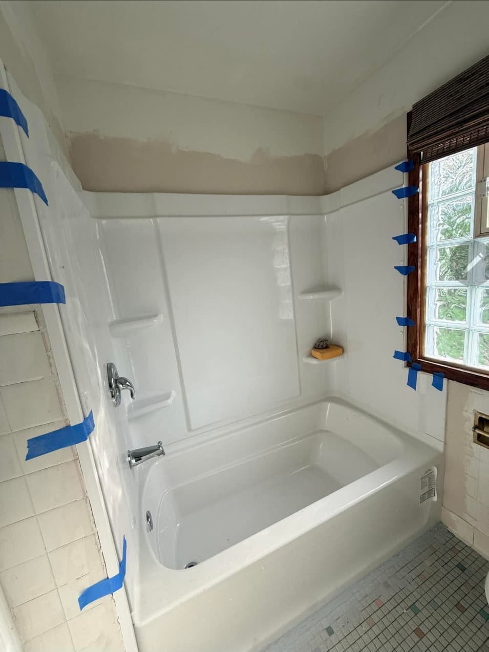 Newly installed white tub and shower surround in a Minneapolis, MN bathroom remodel